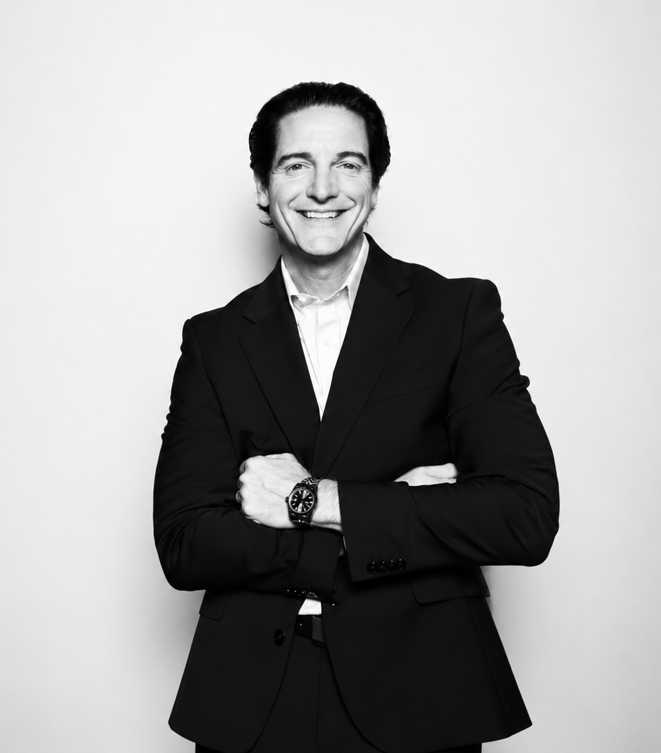 Black-and-white portrait of Rob Bilson, founder of Niagara Strategy Group, in a black suit with arms crossed